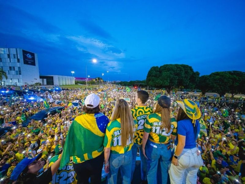 Sob luzes, apoiadores de Flávio e Celina cantam Hino Nacional em ato no DF